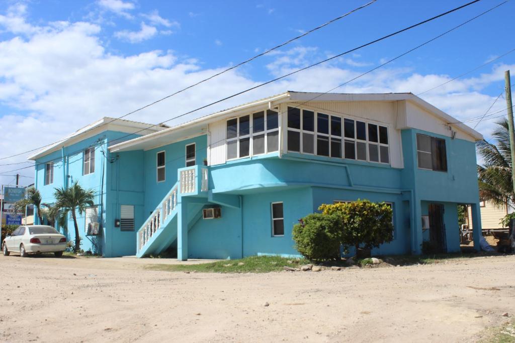 una casa blu con una macchina parcheggiata di fronte di Bonefish Hotel a Dangriga