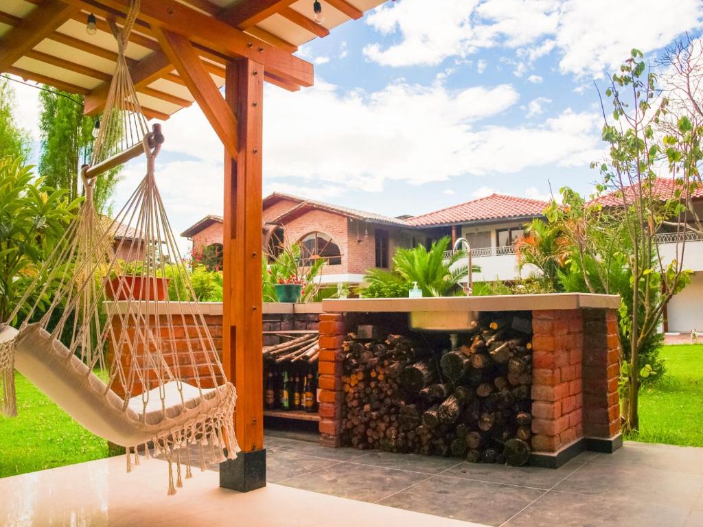 una casa y un patio con chimenea y hamaca en Bamboo Village Place, en Tumbaco