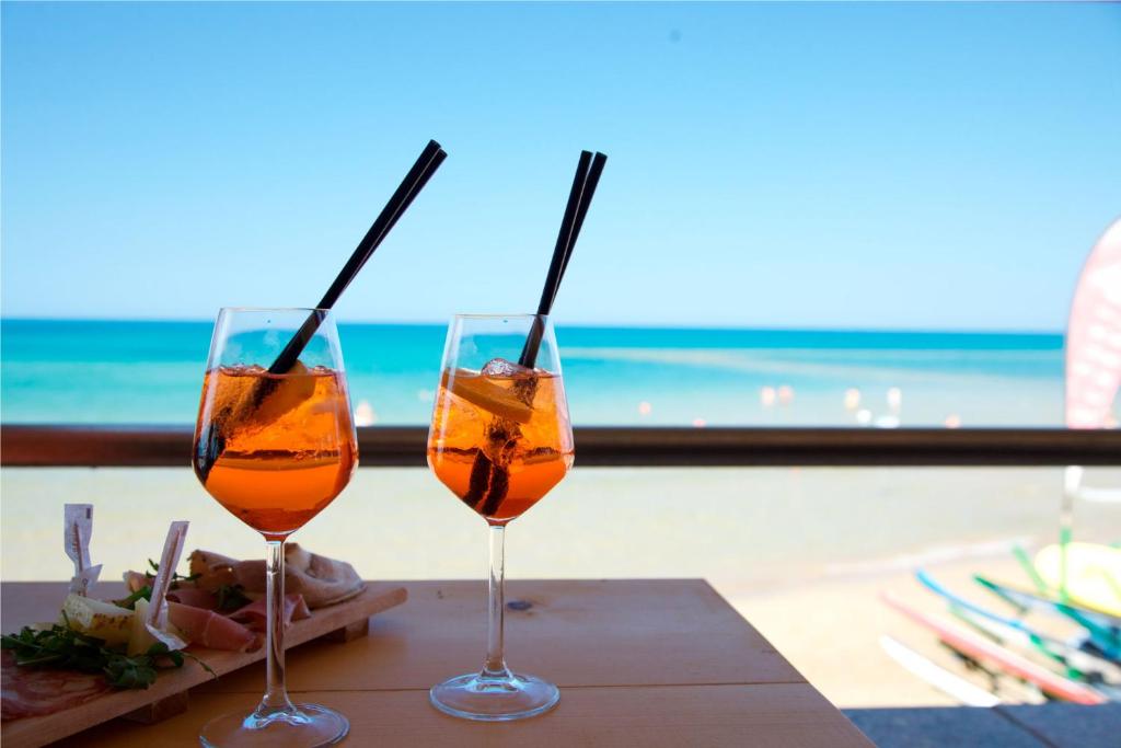 dois copos de vinho sentados numa mesa com vista para o oceano em Appartamento Vacanze Riviera delle Palme em San Benedetto del Tronto