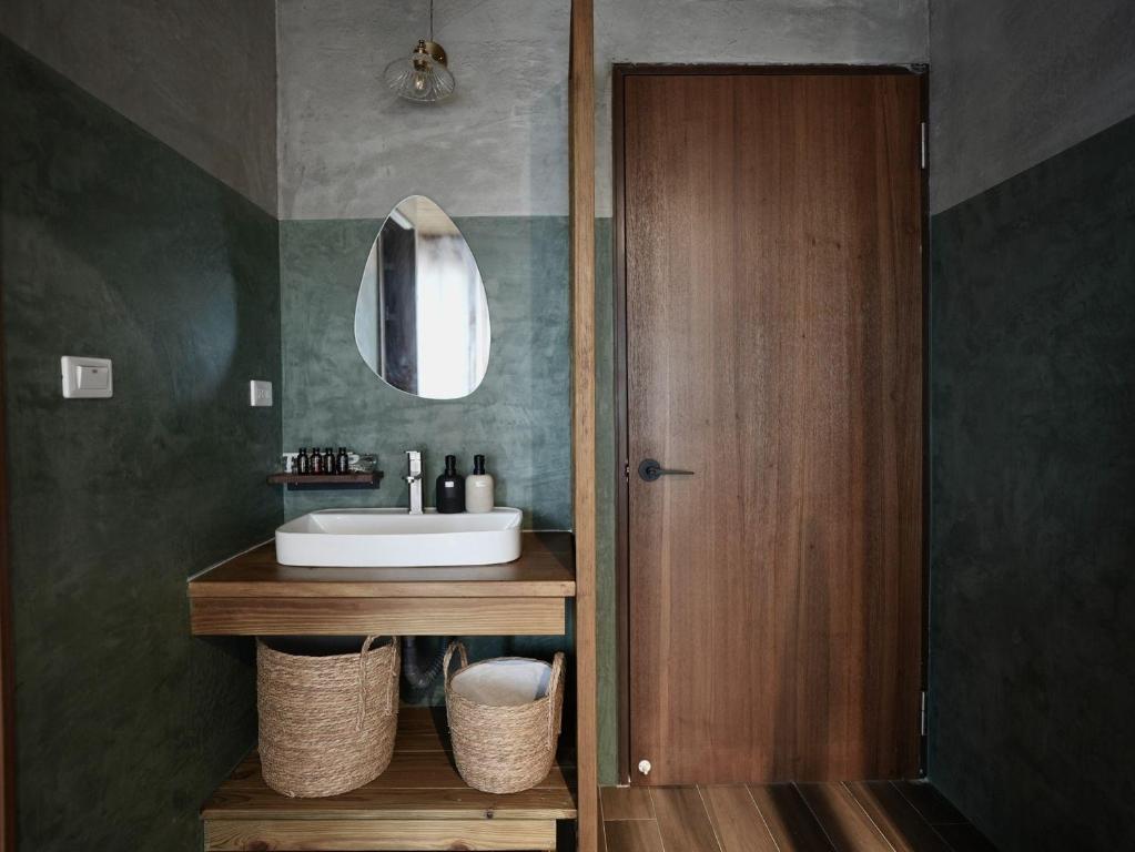 a bathroom with a sink and a mirror at Seaside Snooze in Xiaoliuqiu