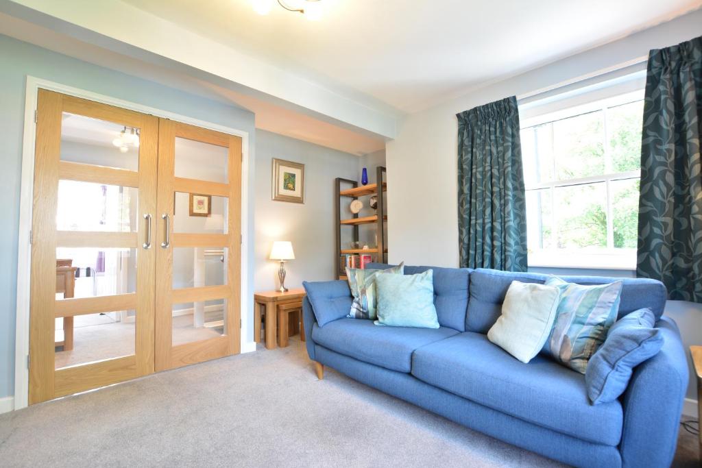 a blue couch in a living room with a window at Beech Apartment in Bowness-on-Windermere