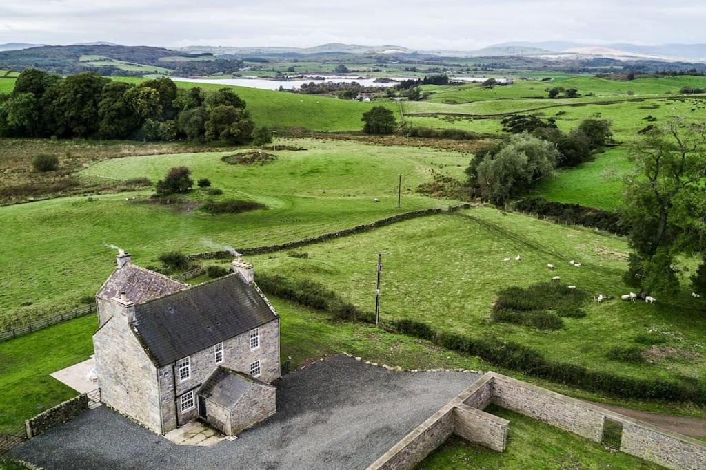 una vista aérea de una antigua casa de piedra en un campo en Blairinnie en Castle Douglas