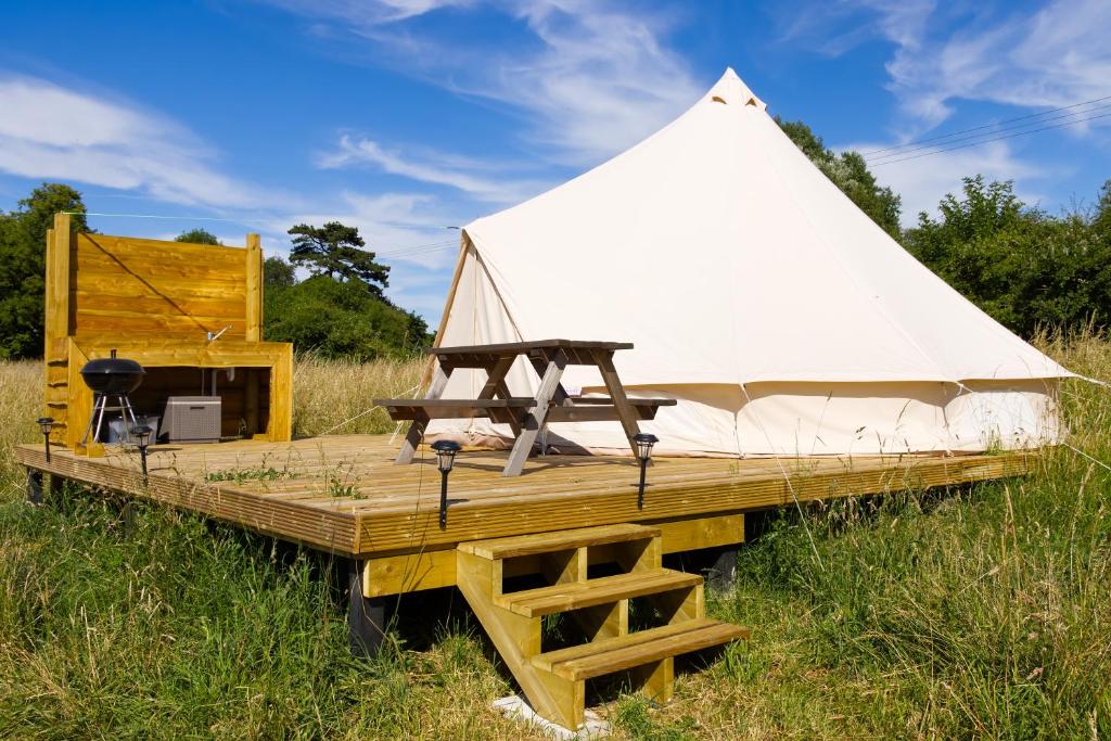 a white tent sitting on top of a wooden deck at Walltree House Glamping in Brackley