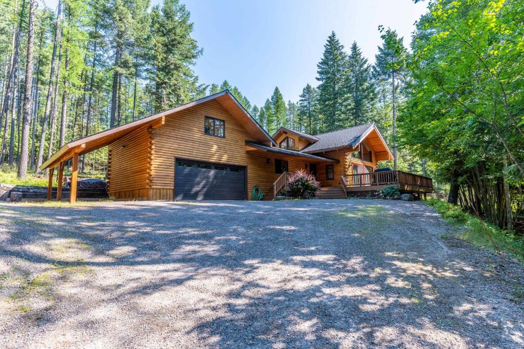 a log home with a garage in the woods at Northwoods Dream Retreat in Whitefish