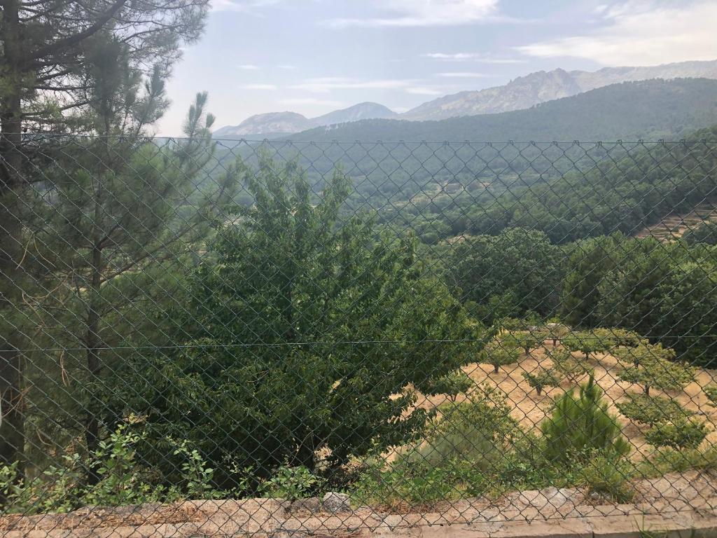 einen Zaun mit Blick auf ein Tal mit Bergen in der Unterkunft Arenalita in S’Arenal