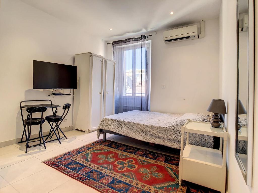 une chambre avec un lit, un bureau et une télévision dans l'établissement Studio Carré d'Or. 2 mins from the Croisette. 143, à Cannes