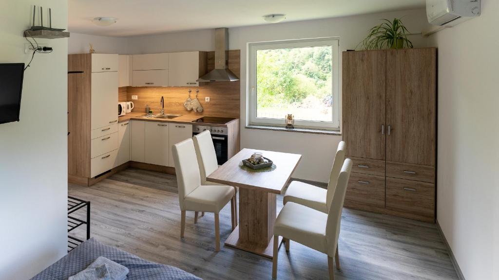 a kitchen and dining room with a table and chairs at GreenRiver Apartment in Spodnje Gorje