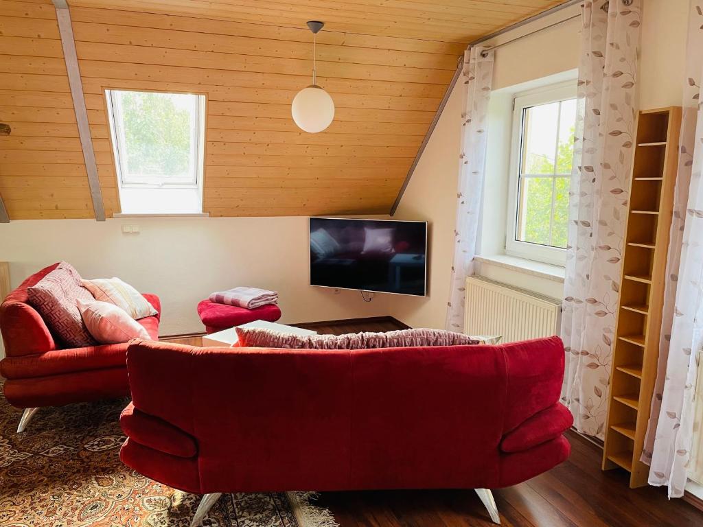 sala de estar con 2 sofás rojos y TV en Ferienappartement am Almesbach Weiden en Weiden