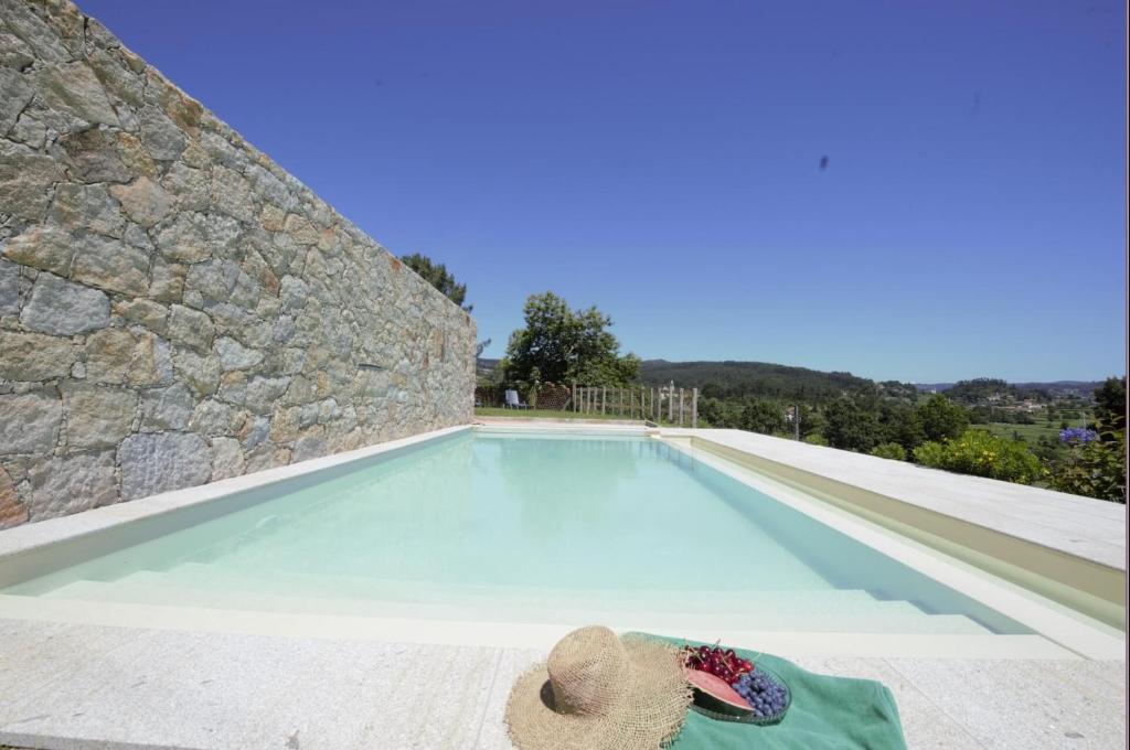 una persona tirada en una toalla junto a una piscina en Casas Viriatus - Turismo Rural, en Paredes de Coura