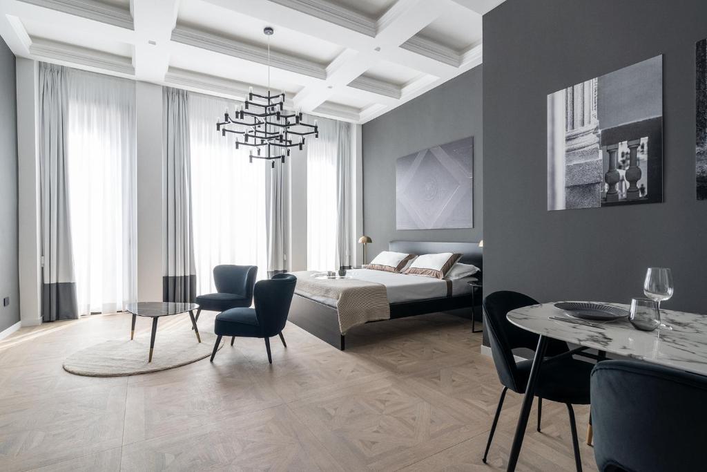 een woonkamer met een bed en een tafel en stoelen bij Il Palazzetto - Bari Sparano in Bari
