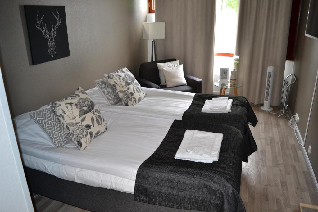 a bedroom with a large bed with towels on it at Comfortable hotel room at Ellivuori Resort in Sastamala