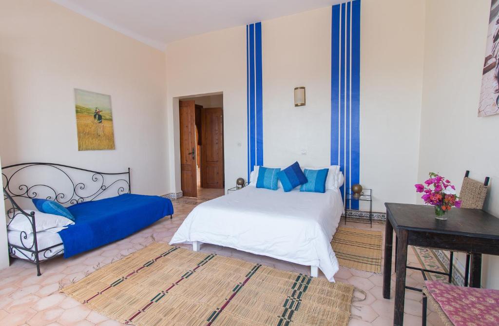 a bedroom with a bed and a desk in a room at Auberge du Marabout in Sidi Kaouki