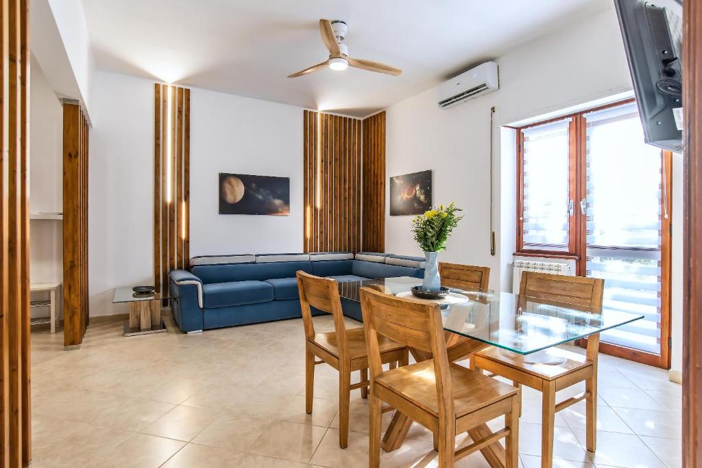 un soggiorno con tavolo da pranzo e divano blu di Appartamento VENERE a Lido di Ostia