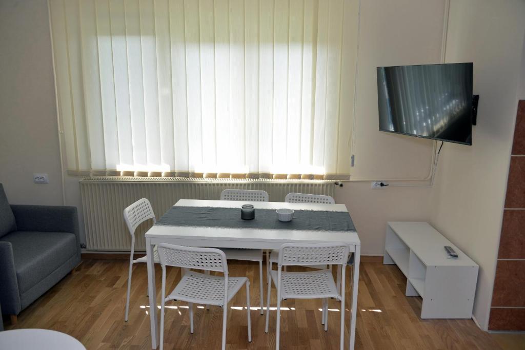 a room with a table and chairs and a couch at Affordable and Newly Renovated 1-bedroom Apartment in Kraljevo