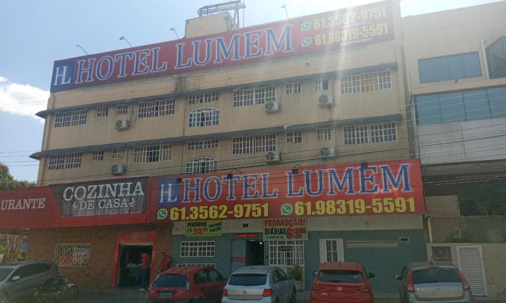 a hotel with cars parked in front of a building at Hotel Lumem Taguatinga Norte in Taguatinga