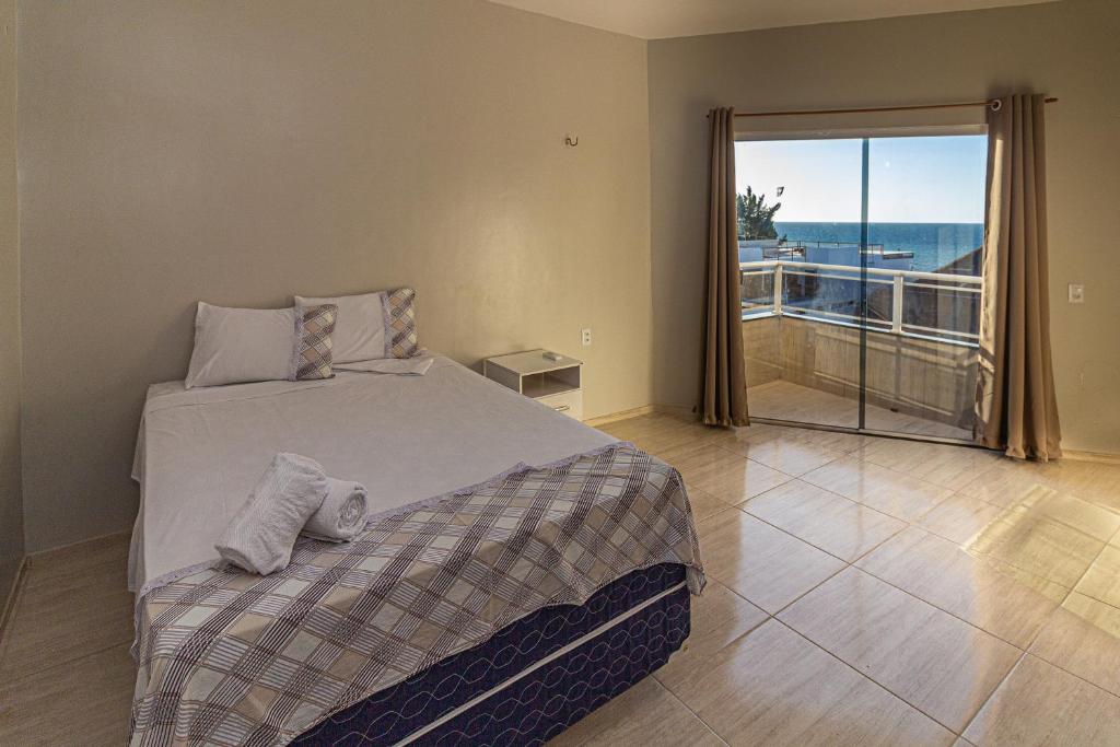 a bedroom with a bed and a view of the ocean at Praieiro pousada in Prea