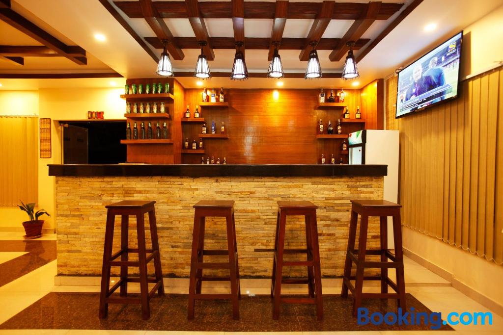 a bar with wooden stools in a restaurant at Hotel Sublime in Pokhara