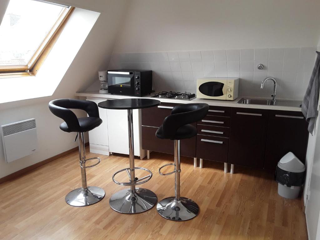 - une petite cuisine avec deux tabourets de bar et une table dans l'établissement Studio lumineux 50 m de la plage, à Mers-les-Bains