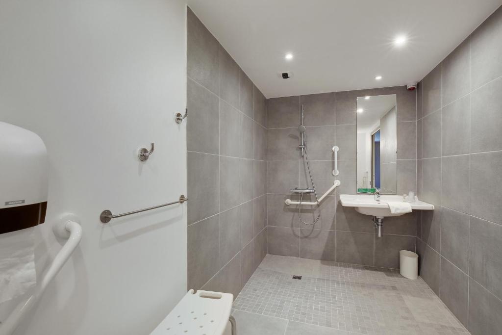 a bathroom with a shower and a toilet and a sink at Hôtel Arcadia in Lannion