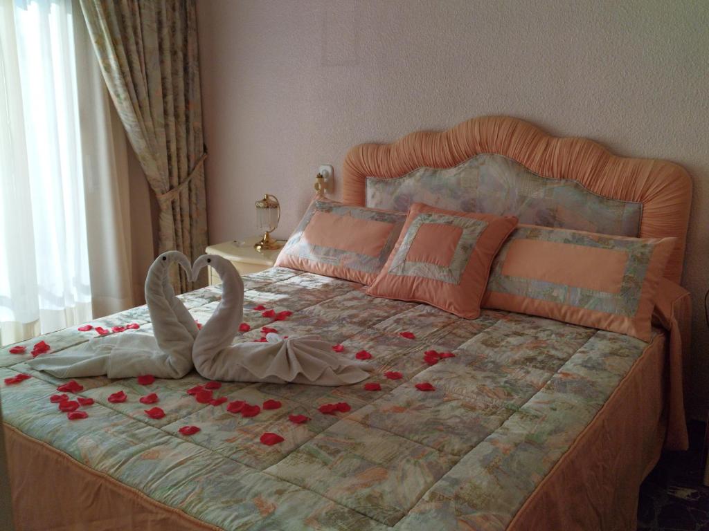 una camera da letto con un letto di rose sopra di Elche Holidays a Elche