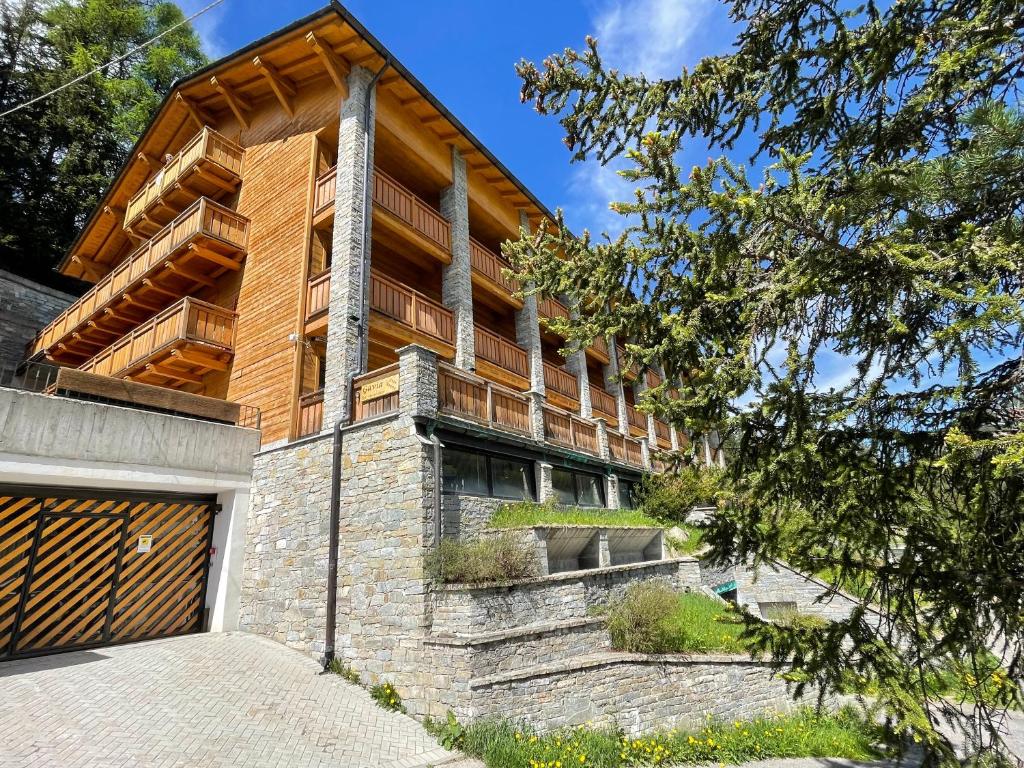 ein Haus auf einem Hügel mit Garage in der Unterkunft Residence Regina delle Alpi in Santa Caterina Valfurva