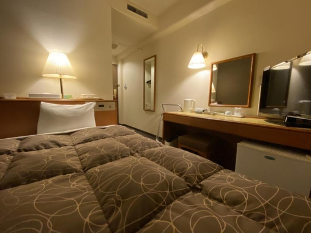 um quarto de hotel com uma cama e uma secretária com um computador em Az Inn Fukui - Vacation STAY 65924v em Fukui