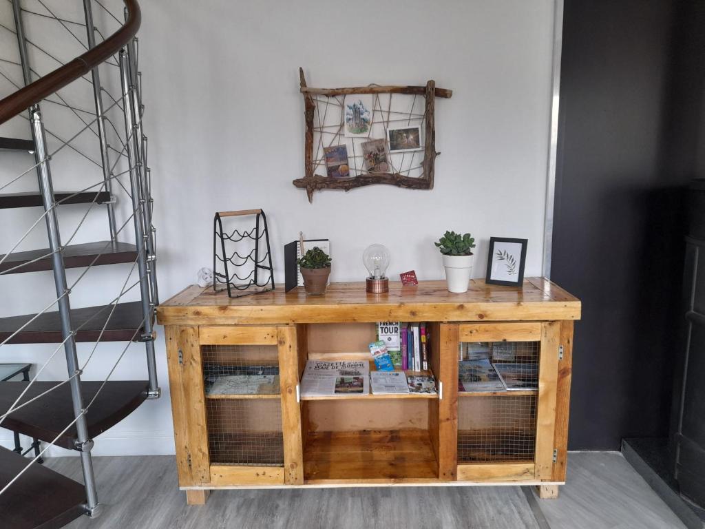 einen Holztisch in einem Zimmer mit Regal in der Unterkunft Le Séverin : Appartement lumineux et chaleureux in Crécy-en-Ponthieu