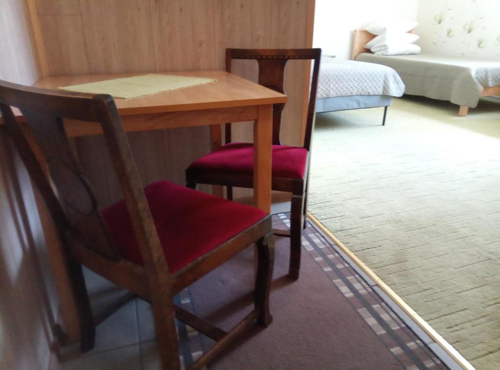 a wooden table with two chairs and a table and a bed at TäheMaja6 in Viljandi