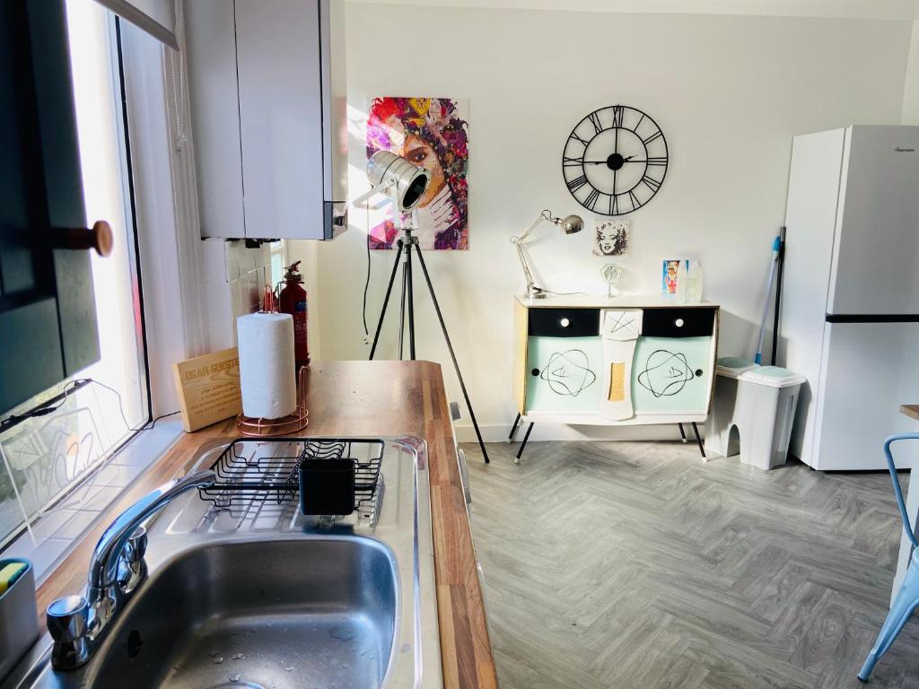 a kitchen with a sink and a counter top at Funky cozy cottage with outside space in Eastbourne