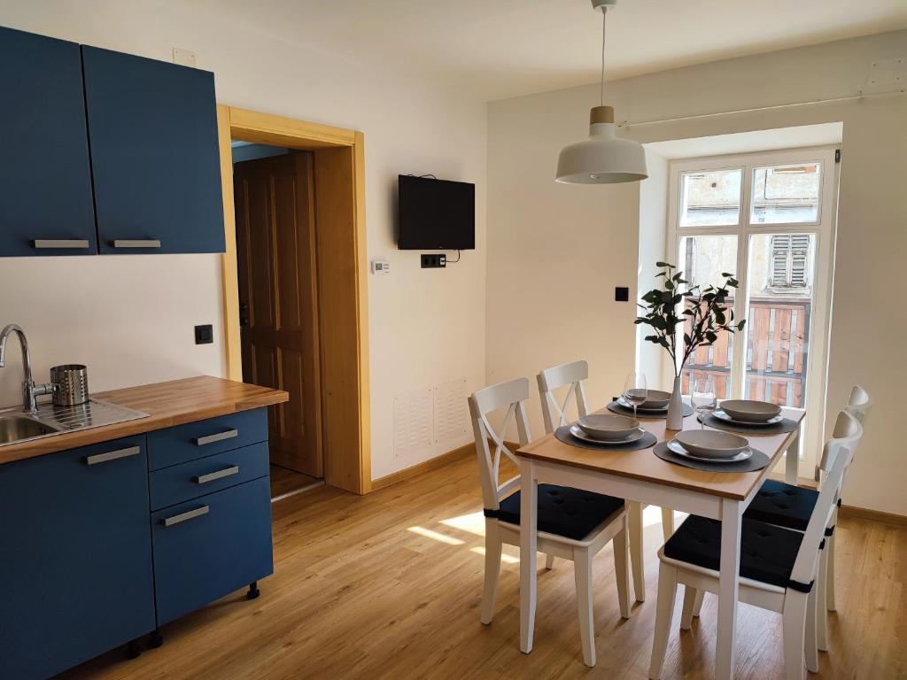 cocina y comedor con mesa y sillas en Corner House Apartments near Lake Bled, en Radovljica