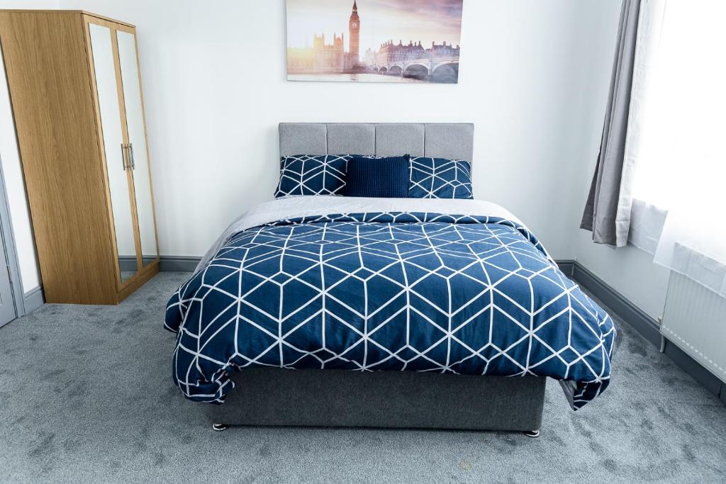 1 dormitorio con 1 cama con edredón azul y blanco en Empress House en Mánchester