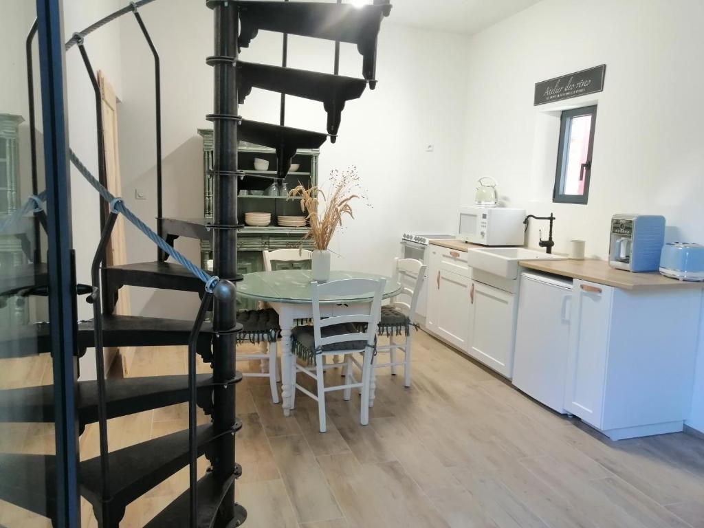eine Küche und ein Esszimmer mit einer Wendeltreppe und einem Tisch in der Unterkunft Chez Joséphine 