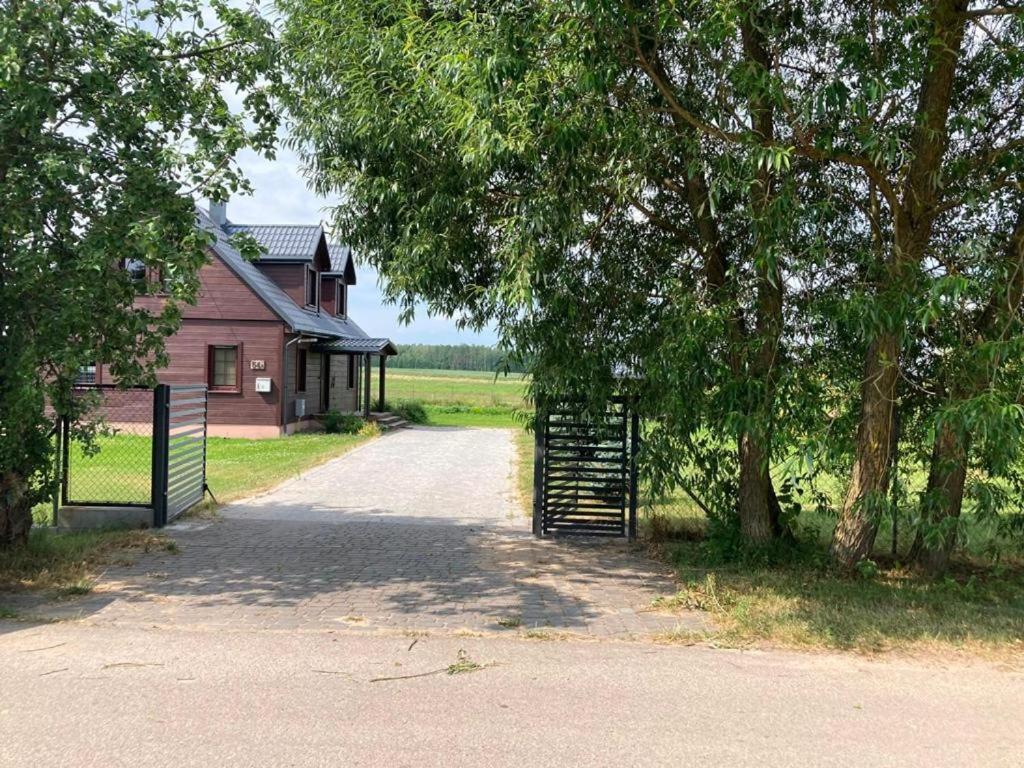 una entrada que conduce a una casa con una puerta y árboles en Domek nad stawem, 