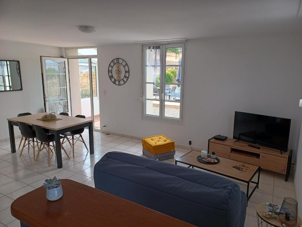 a living room with a blue couch and a tv at Maison Face au Mont avec extérieur in Avranches