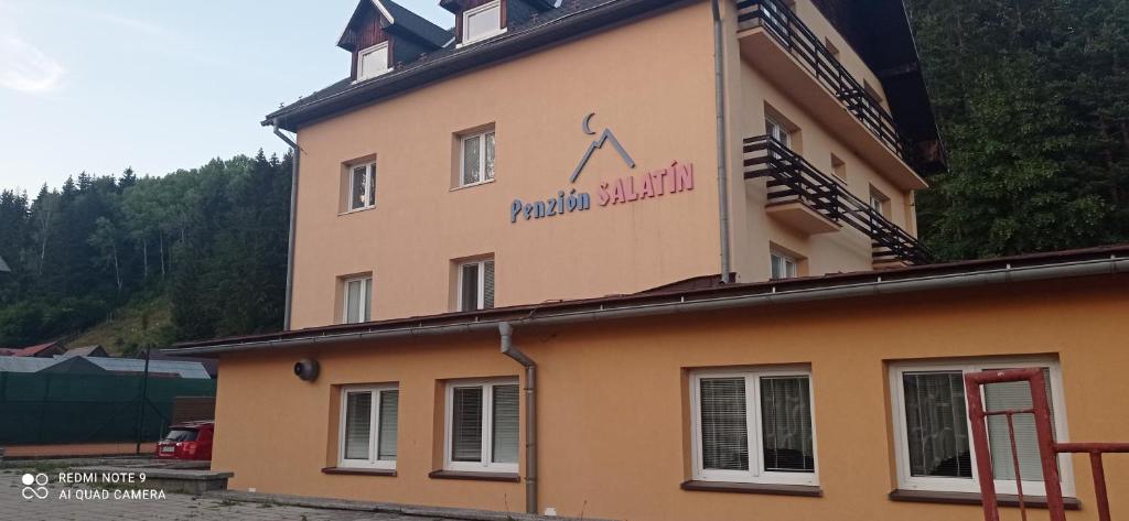 a building with a sign on the side of it at Salatín in Ružomberok