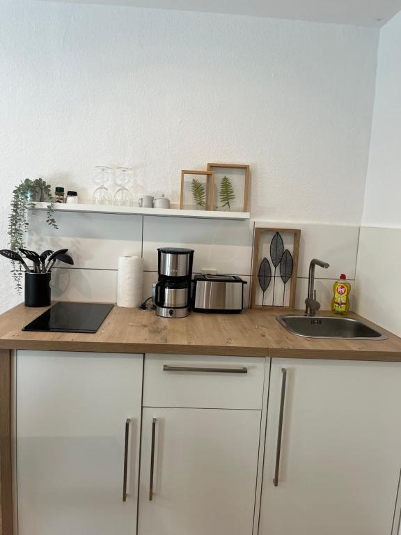 a kitchen counter with white cabinets and a sink at Deich Quartier 9.3 in Dorum Neufeld
