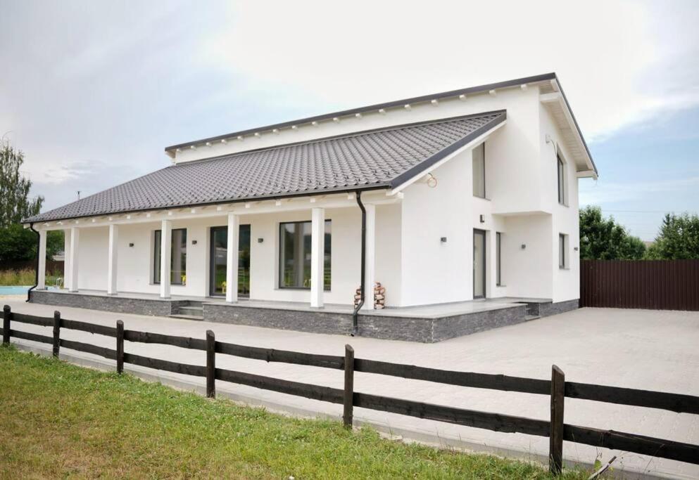 a white house with a fence in front of it at Vila Cataleya in Întorsura Buzăului