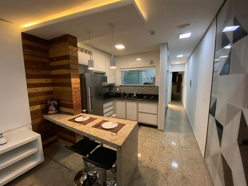 uma cozinha com uma mesa e um frigorífico em Apart Hotel Seg Total Lofts Encantadores em Mogi Guaçu
