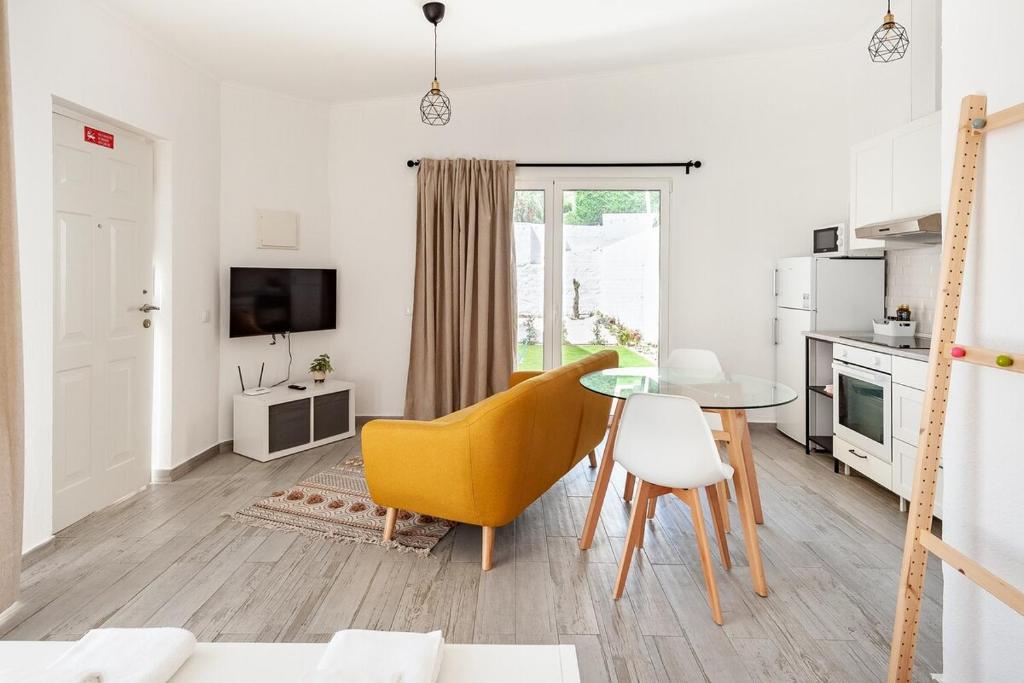 a living room with a table and a yellow chair at Sintra Studio Garden - Free Parking in Sintra