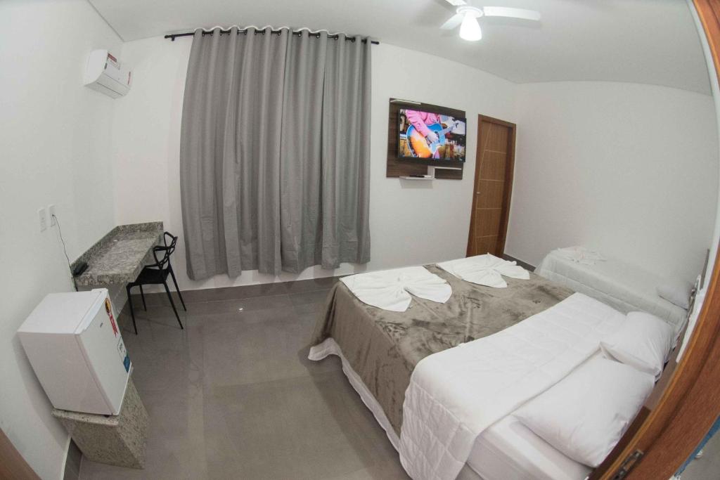 a hotel room with a bed and a mirror at Hotel Esmeralda Verde in Teófilo Otoni