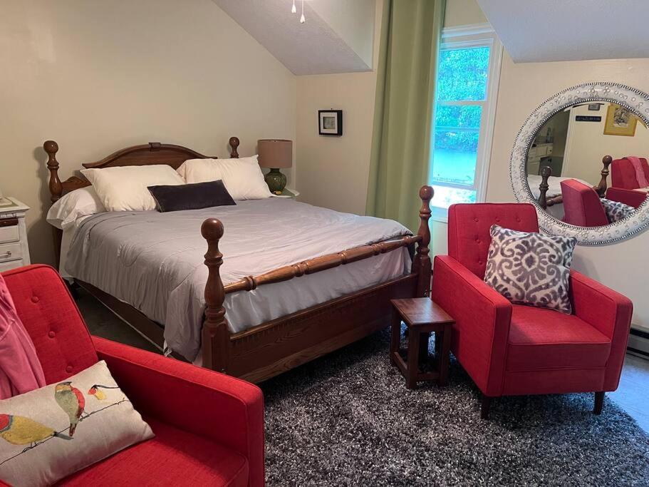 a bedroom with a bed and two chairs and a mirror at Centrally Located Resort in The High Country RELAX in Newland