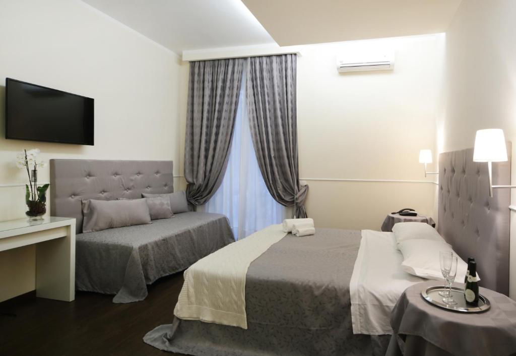 ローマにあるCaesar Placeのベッド2台と窓が備わるホテルルームです。
