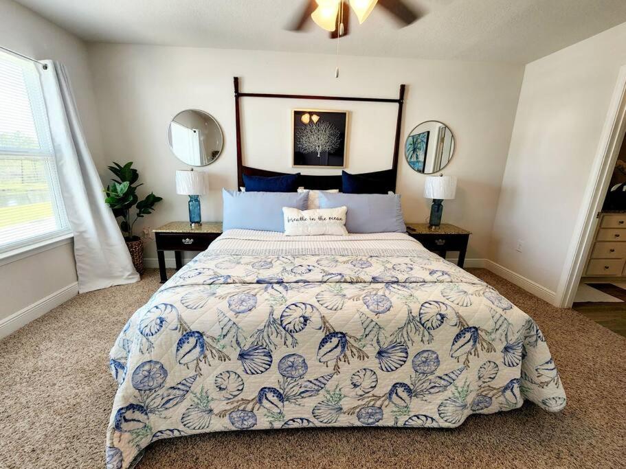 a bedroom with a large bed and two mirrors at ENTIRE HOME- Gorgeous 3br Townhome Pool, Grill, Washer, Dryer, 2 FREE drive up spaces Sleeps 6 Close to everything PCB! in Panama City Beach