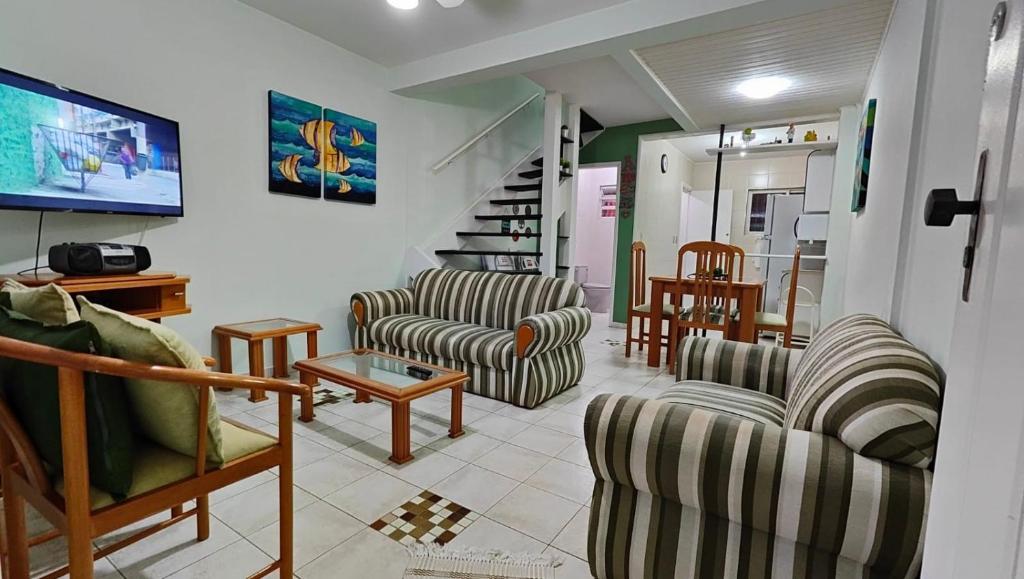 a living room with two chairs and a tv at Casinha de Boneca em Juquey in Juquei
