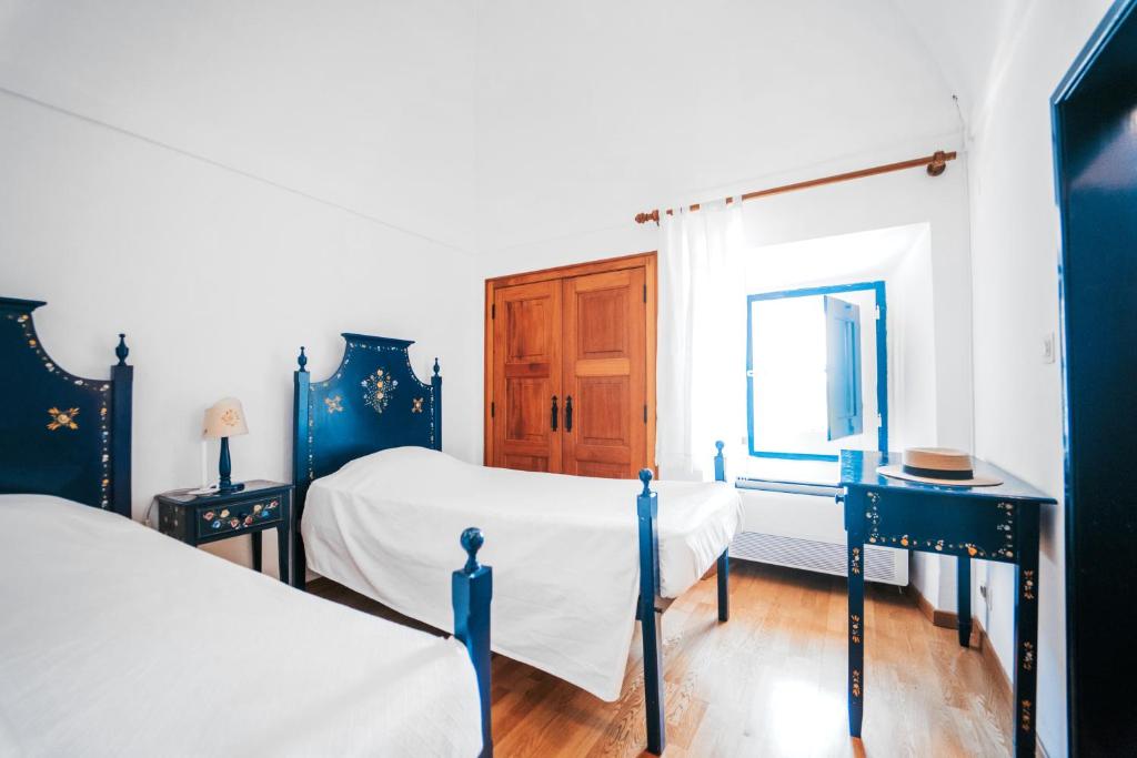 a bedroom with two beds and a window at O Conventinho in Évora