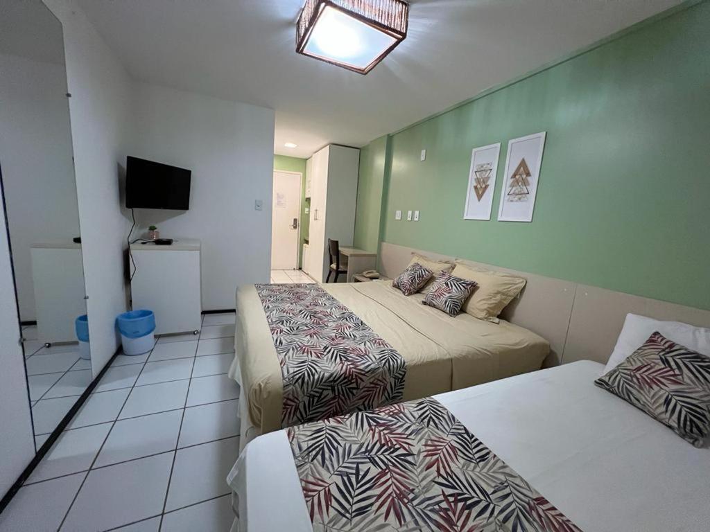 a hotel room with two beds and a television at Gran Lençois Flat Residence - Barrerinhas (Aptº Particular) in Barreirinhas