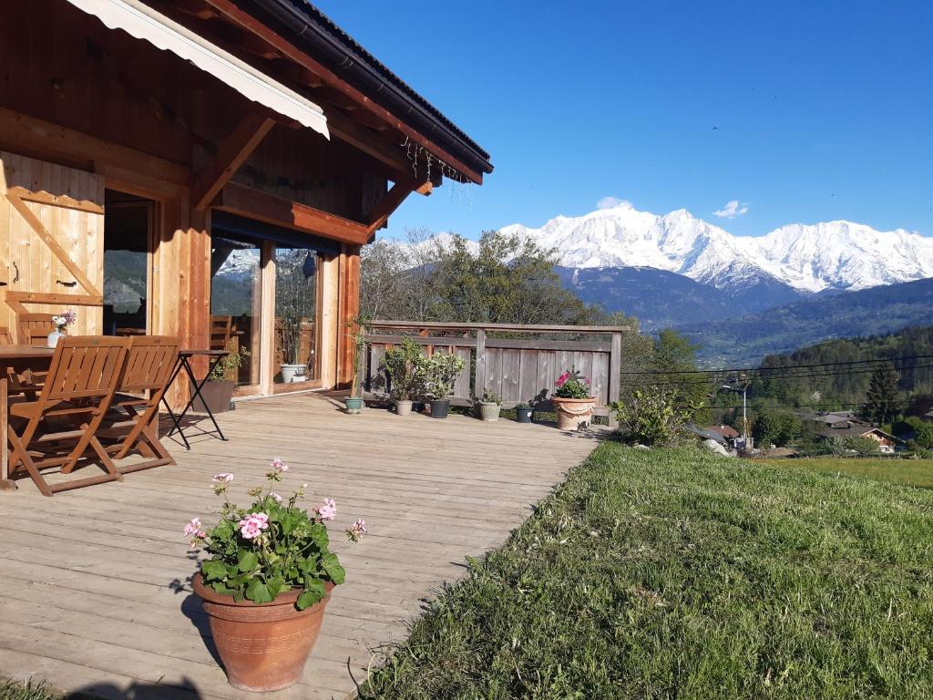 a porch of a cabin with mountains in the background at L'Eterlou 74 in Sallanches