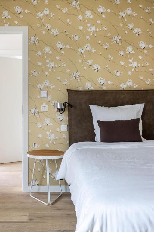 a bedroom with a bed with a flower patterned wall at B&amp;B Leonie in Alveringem