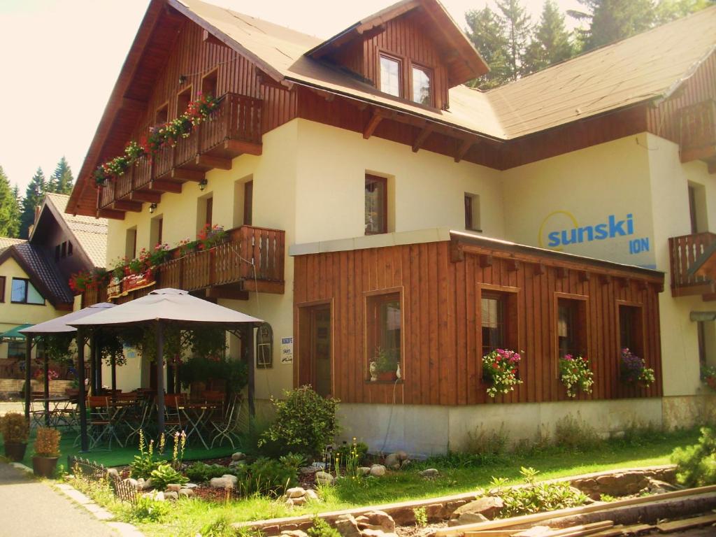 a building with an umbrella in front of it at Penzion Sunski in Harrachov