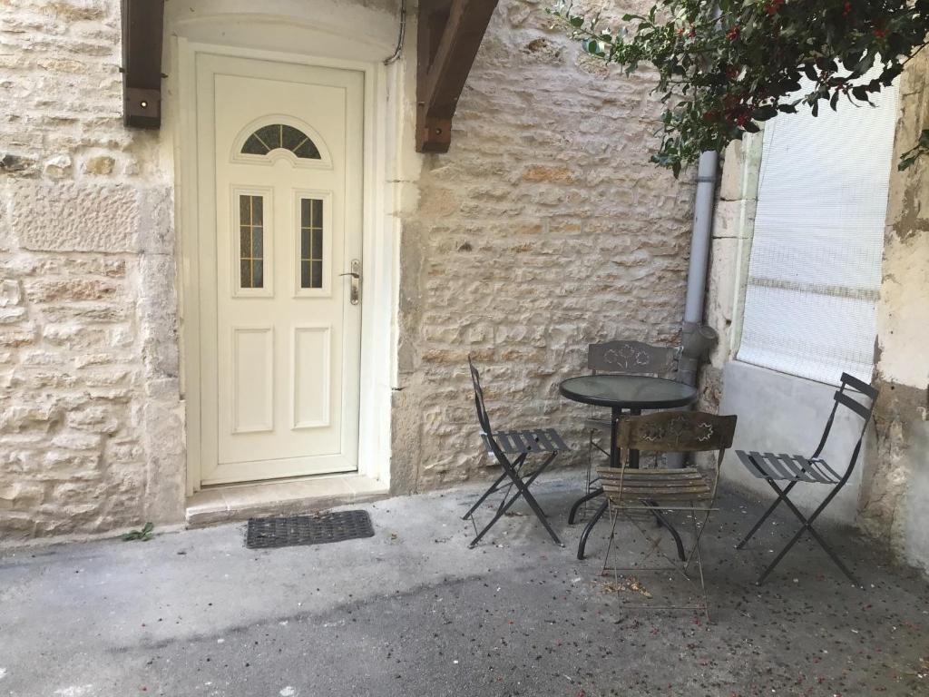 una mesa y sillas sentadas frente a una puerta en Charmant studio au coeur du centre ville, en Chagny